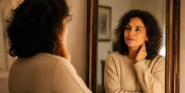 Midlife woman looking at her reflection while navigating identity changes in menopause